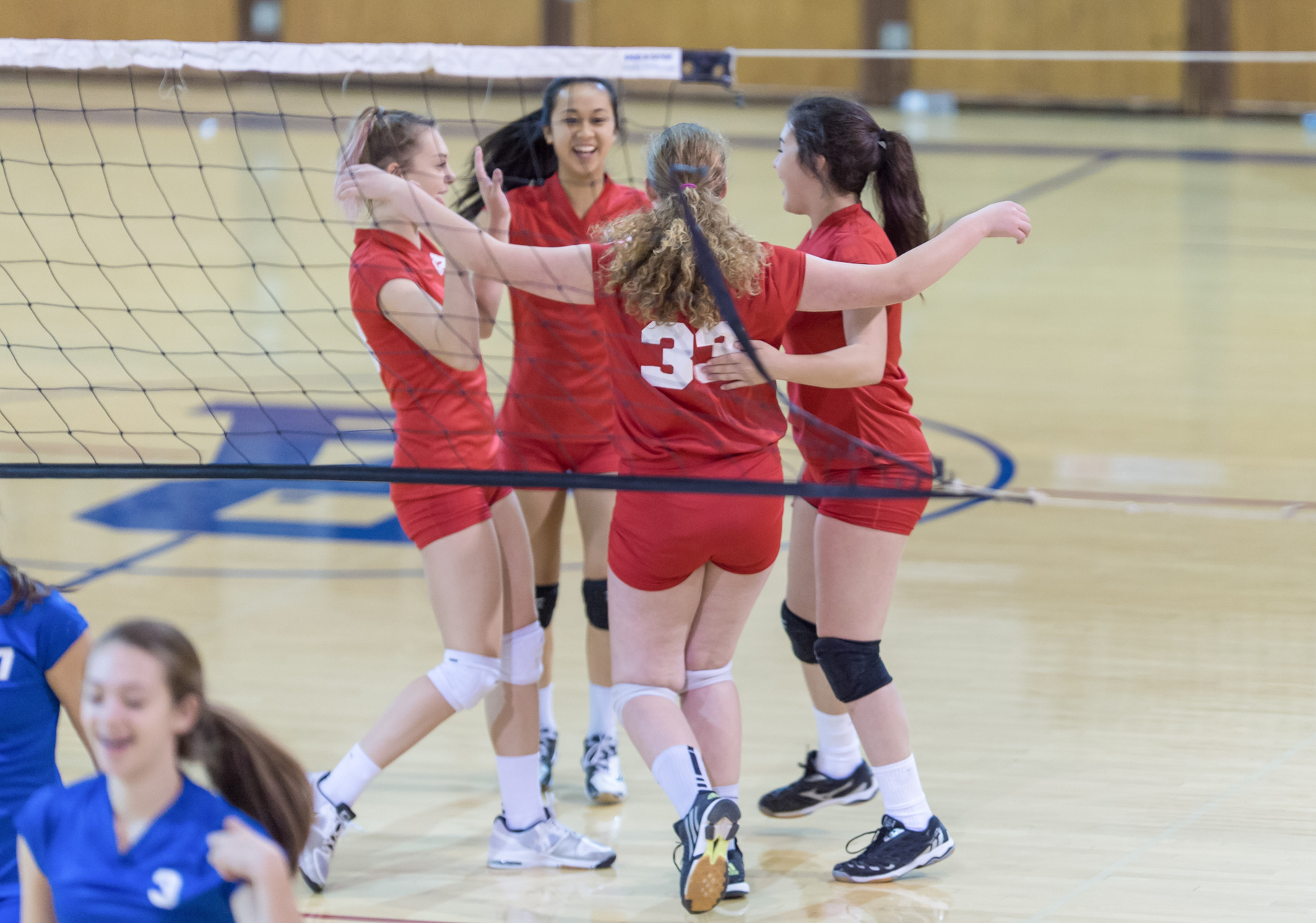 Female high school volley ball team celebrating